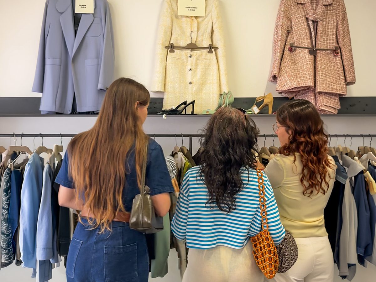 A small group browsing racks in a Milan vintage shop